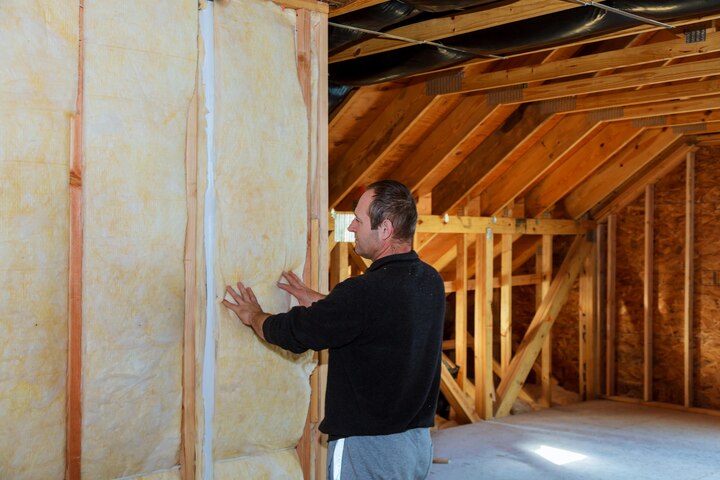 Installer insulating house attic using mineral wool